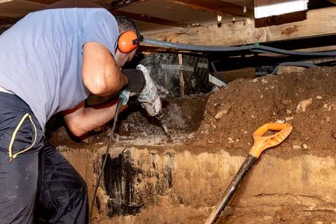 Man builder repairman drill perforator hole in concrete in basement wooden .. Stock Photos