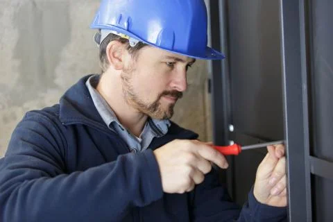 A man builder is screwing wall Stock Photos