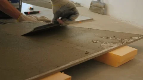 Man builder spreads mortar with joint knife over marble tile Video stock 151810369
