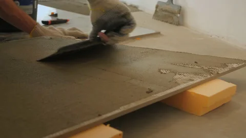 Man builder spreads mortar with joint knife over marble tile Video stock 152852740