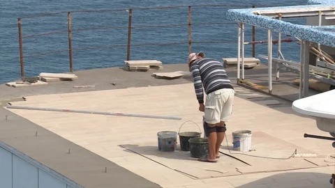 The man builder stirs the concrete mortar on the roof of the hotel. Stock Footage 95626461