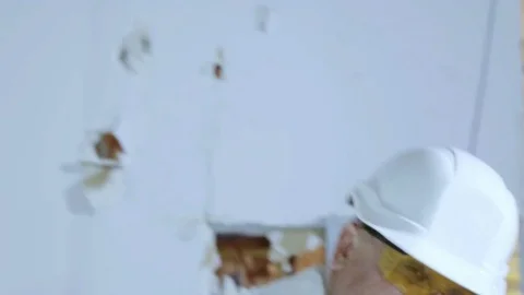 A man builder swings a sledge hammer at the camera. Stock Footage 81356006