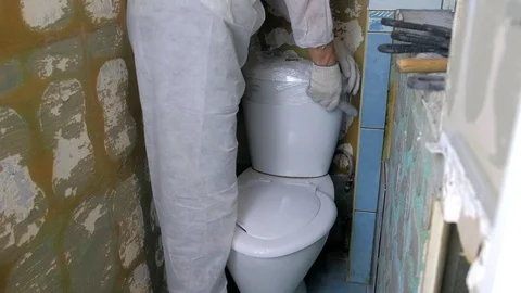 Man builder in uniform making renovation in toilet lavatory room, closeup view. Video stock 125040488