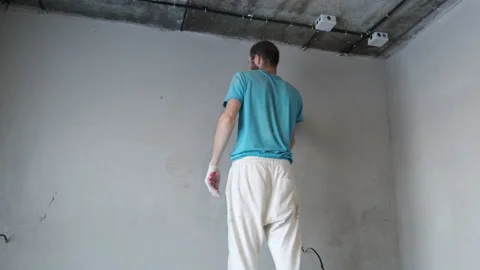Man Builder Work at Construction Site. Trowel Levels Plaster on Wall. Plastering Stock Footage 168356114