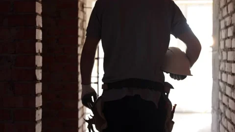 A man builder with a working helmet in his hands at a construction site. Stock Footage 160887693