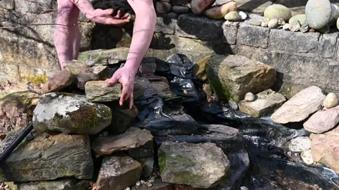 Man building artificial stream in garden Stock Footage 150693956