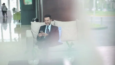 Man in building lobby using smart phone Vídeos de archivo 75171566