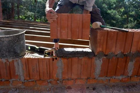 A man is building a wall of ceramic blocks. Stock Photos