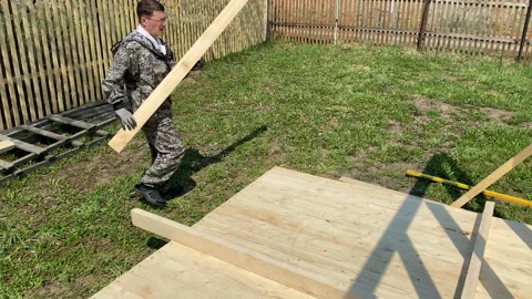 A man builds the frame of a gazebo. Stock Footage 154201813