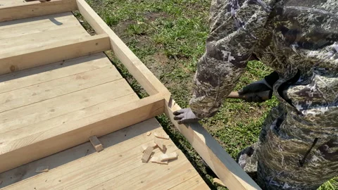 A man builds the frame of a gazebo. Stock Footage 154202733