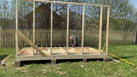 A man builds the frame of a gazebo. Stock Footage 154204028