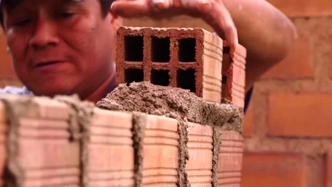 Man builds a wall with bricks and mixes cement with sand. Vídeos de archivo 153449433