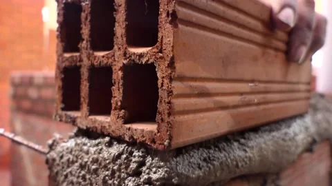 Man builds a wall with bricks and mixes cement with sand. Stock Footage 153449709