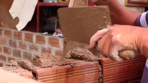 The man builds a wall with bricks and mixes cement with sand. Video stock 153449798
