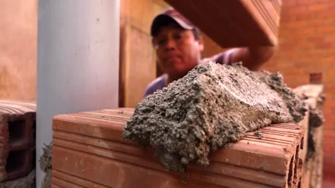 The man builds a wall with bricks and mixes cement with sand. Stock Footage 153450033