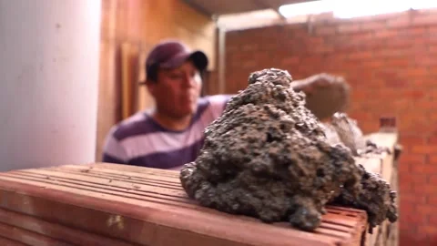 The man builds a wall with bricks and mixes cement with sand. Stock Footage 153450257