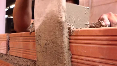 The man builds a wall with bricks and mixes cement with sand. Video stock 153452011