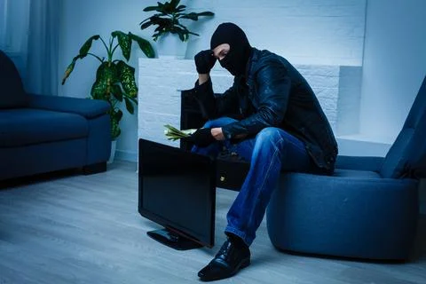 Man burglar stealing tv set from house Stock Photos