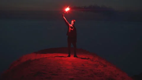 The man with a burning fire stick standing on the mountain Видео 143561412