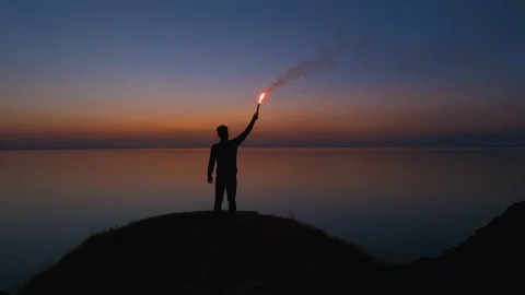 The man with a burning fire stick stands on the seascape background. slow motion Stock Footage 143570667