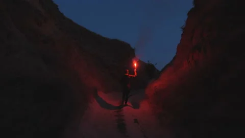 The man with burning firework is running in the mountains. slow motion Vídeos de archivo 143563551