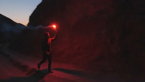 The man with burning firework is running in the mountains. slow motion Stock Footage 143563559