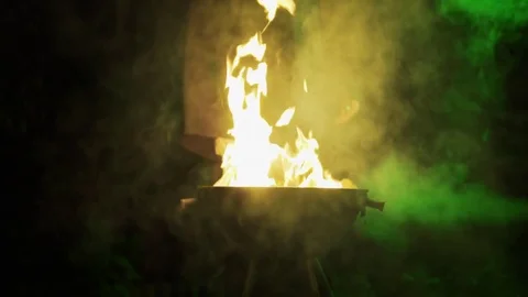 A man burning paper files on big flame with a lot of smoke coming out at night Stock Footage