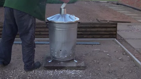 Garden incinerator bin burning waste from the garden. Stock Photo