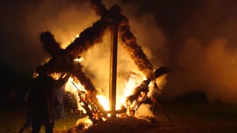 Man burns a fire sculpture in shape of the Latvian character "oak", midsummer Stock Footage 253410230