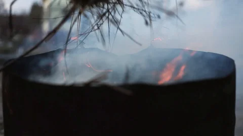A man burns garbage in a barrel Stock Footage 129709548