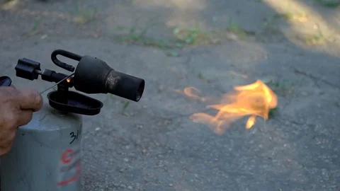 A man burns his hand with fire. Gasoline Blowtorch. Pig roasting lamp. Stock Footage 113668280