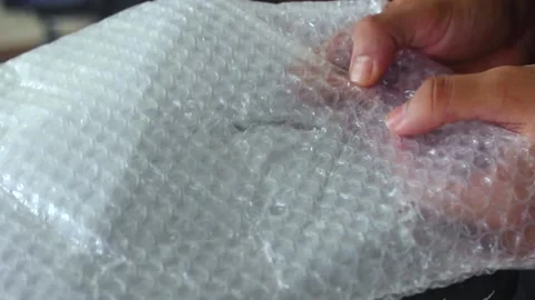 Man bursts bubbles on a packaging bubble wrap Video stock 214484121