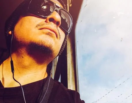 Man in a bus. Handsome young Peruvian man wearing sunglasses looking through bus Stock Photos