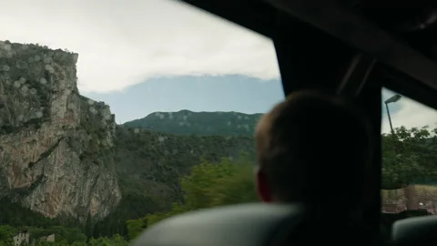 Man on bus looks out of window and sees mountains Stock Footage 170424443