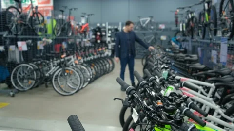 A man in business clothes chooses a bicycle in a sports store Stock Footage 169472053