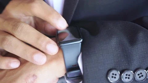 A man in a business suit checking a smart watch on his hand Stock Footage 322159631