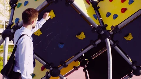 A man in a business suit checking swing in the park 動画素材 95366884
