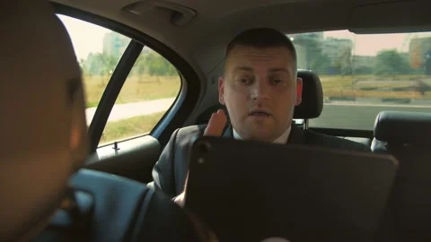  Man in a business suit doing videocall on tablet at car. Stock Footage 201086119