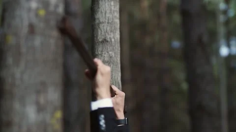 A man in a business suit pulls himself up on a crossbar between trees in the for Stock Footage 147329767