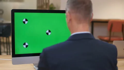 A man in a business suit works at a computer with a large monitor, green screen Stock Footage 231893755