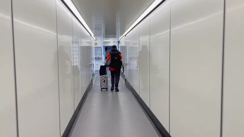 The man is busy walking in the corridor leading to the plane cabin with his lugg Stock Footage 170938415