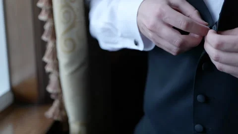 Man buttoning up black vest close up Stockbeeldmateriaal 170381829