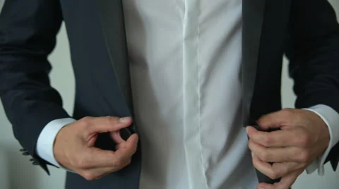 Man buttoning a button on his jacket Видео 67658892
