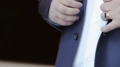 Man buttoning a button on a stylish blue jacket Stock Footage 78865869