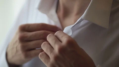 Man buttoning a button on a white shirt 스톡 동영상 84993806