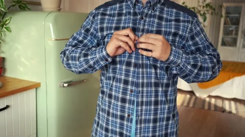 Man buttoning the buttons on his shirt Stock Footage 157886023