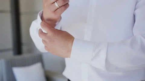 The man buttoning buttons on the sleeves of his shirt. Close-up. Businessman but Stock Footage 111805631