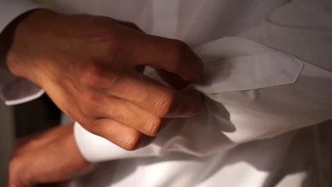 Man buttoning buttons on sleeves in white shirt close up Stock Footage 127431009