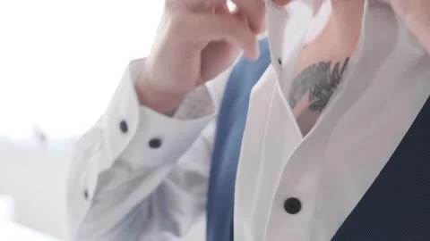 Man buttoning the collar of his shirt close-up Stock Footage 162479401