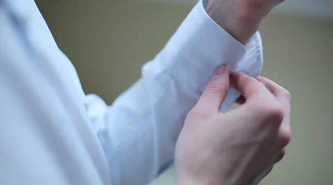 Man buttoning cufflinks on white shirt Stock Footage 64916574